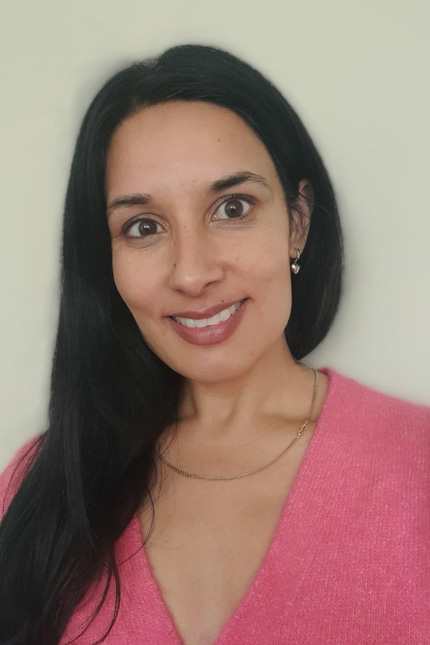 Portrait of writer Manjot Dhaliwal with long black hair and wearing a pink top.