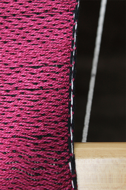Close up photograph of bright pink satin stitches